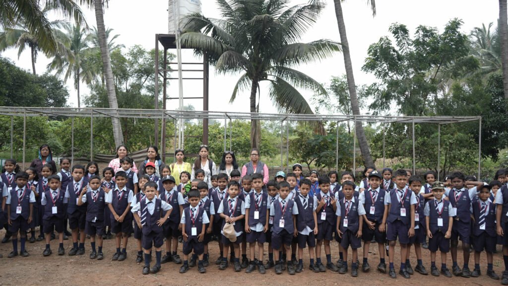 School students and teachers posing together during a visit to NatureNestt Agro Tourism near Pune